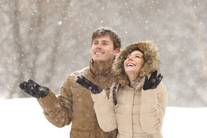 Couple together smiling and looking at the snow falling from the sky to represent Dr. Karen Gless post Staying Sane during the Season